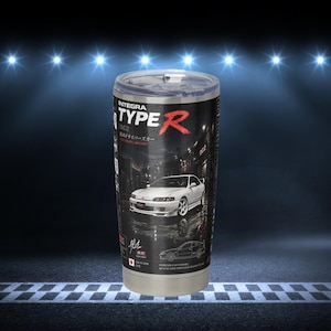 May include: A stainless steel tumbler featuring a graphic print of a white Integra Type R car. The design includes the text INTEGRA TYPE R, DC2, and Japanese characters. The tumbler has a clear plastic lid and a metallic base, showcasing a detailed automotive theme with a dark background.