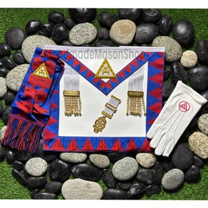 May include: A Masonic apron, sash, and gloves set. The apron is white with blue and red trim, gold fringe, and a pendant. The sash is blue and red with gold fringe. The white gloves have a red emblem.