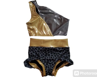 May include: A two-piece dance outfit with a gold and gray one-shoulder crop top and black and gold high-waisted shorts with a leopard print.