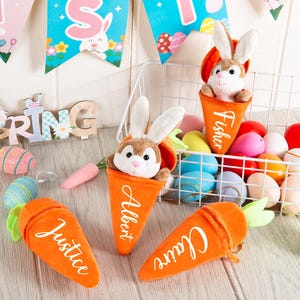 May include: A seasonal Easter display with plush bunny toys in orange carrot pouches, each with a name. A wire basket contains colourful Easter eggs. Decorative banners and a wooden spring sign add to the festive scene.