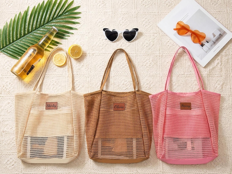 Pode incluir: Tr&ecirc;s sacolas de rede bege, marrom e rosa, cada uma com um patch retangular. A sacola bege tem "Shirley" no patch, a marrom "Olivia" e a rosa "Harry".