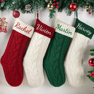 May include: Four cable-knit Christmas stockings in red, white, and green, each with a white cuff and a name embroidered in a contrasting color: Rachel, Vivien, Martin, and Harvey. Festive holiday decor.