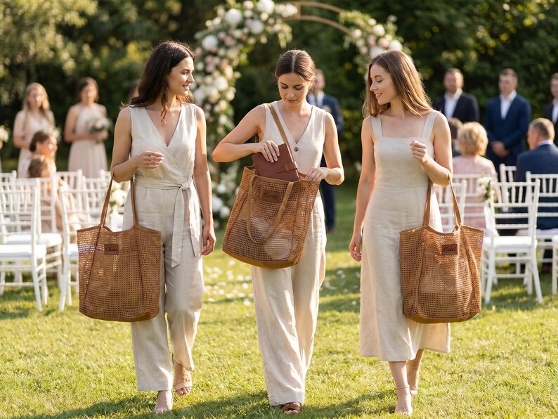 Pode incluir: Tr&ecirc;s pessoas caminhando na grama, cada uma carregando uma grande sacola de malha marrom. Elas est&atilde;o usando macac&otilde;es e vestidos de cores claras. O fundo inclui um arco de casamento, cadeiras e outros convidados, sugerindo um cen&aacute;rio de casamento.