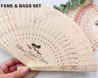 May include: Wooden hand fan with intricate cut-out designs of moons and stars. The fan is personalized with the text "Melissa's Bridal Shower" and the date 09.16.2025. The text "Custom Your Text" is also visible. The image is labeled "FANS & BAGS SET".