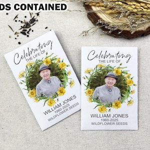 May include: Two white cards with a floral wreath design and a photo of a man. The text on the cards reads "Celebrating the life of William Jones 1960-2025 Wildflower Seeds".