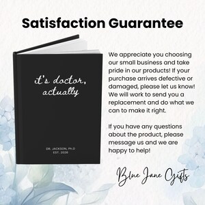 May include: A black notebook with the text "it's doctor, actually" in white. The notebook also includes the text "DR. JACKSON, Ph.D EST. 2026". The image includes the text "Satisfaction Guarantee" and "Blue Jane Gifts".