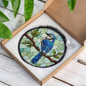 a blue bird sitting on top of a tree branch