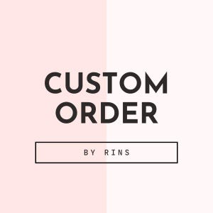 May include: A graphic with the words "CUSTOM ORDER" in bold black font, above a rectangular box with the text "BY RINS" in a smaller font. The background is divided vertically into two sections, one light pink and the other a slightly darker pink.