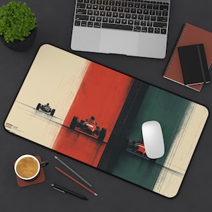 May include: A rectangular desk mat featuring a vintage racing car design. The mat has a black border and a cream-colored background with vertical stripes of red and green. Three race cars are depicted in motion, with a white computer mouse on the right.