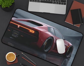Puede incluir: Alfombrilla de ratón rectangular negra con un coche deportivo rojo y una luz trasera naranja. El coche está en ángulo, mostrando su diseño elegante. Un ratón de ordenador blanco está sobre la alfombrilla.