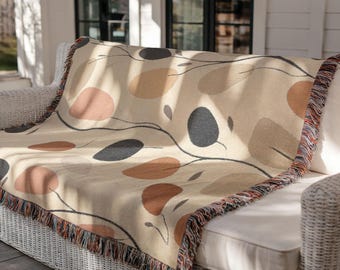 Coperta decorativa neutra con motivo a foglie, arazzo intrecciato nei toni della terra per divano o camera da letto, decorazione autunnale in stile minimalista.
