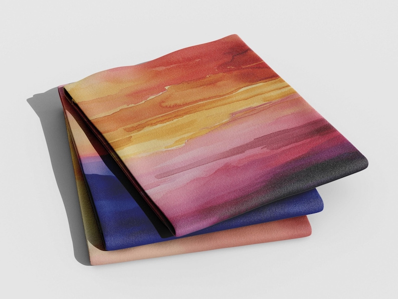 K&ouml;nnte beinhalten: Drei gefaltete Stoffquadrate mit einem Aquarell-Sonnenuntergangsdesign. Das obere Quadrat ist leuchtend orange, gelb und rosa, das mittlere Quadrat ist dunkelblau und das untere Quadrat ist hellpfirsich.