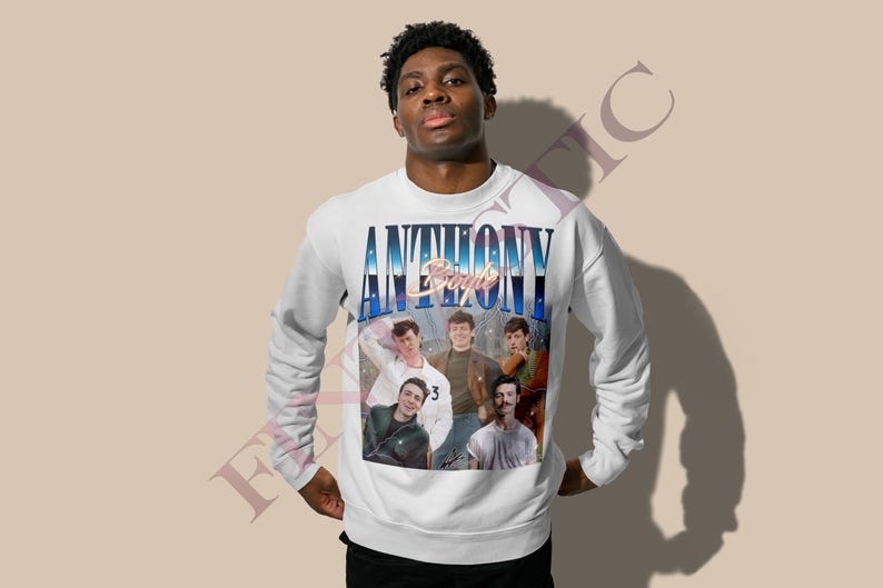 May include: White sweatshirt featuring a group of people with the text "ANTHONY" in a blue and white gradient font. The sweatshirt has a vintage style design with a photo collage of the group. The long-sleeved crew neck sweatshirt is a casual style.