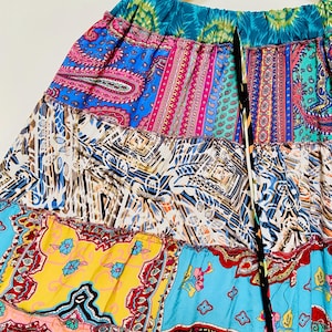 Puede incluir: Falda patchwork colorida con una variedad de patrones y colores, incluyendo dise&ntilde;os de cachemira y florales. La falda tiene una cintura con cord&oacute;n y una mezcla de colores vibrantes como azul, rosa, amarillo y turquesa.