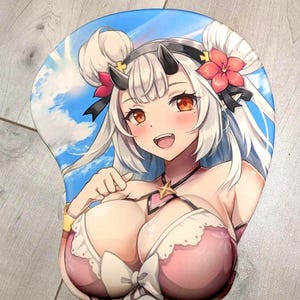 May include: A 3D mouse pad featuring an anime-style character with white hair, small black horns, and orange eyes. The character wears a pink and white outfit with a star pendant against a blue sky background. The pad includes a raised wrist rest.