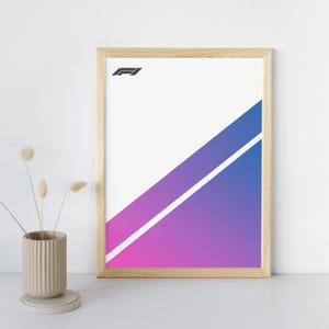 Puede incluir: Un póster enmarcado con el logotipo de Fórmula 1 en la esquina superior izquierda. El póster presenta un fondo blanco con un degradado diagonal de rosa a azul, dividido por una franja blanca. El marco es de madera clara.