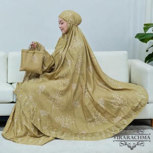 May include: A beige prayer shawl with a floral pattern and a matching bag. The shawl has a ruffled edge and is made of a soft, flowing fabric.