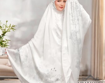 Puede incluir: Chale de oración blanco con un patrón floral. El chal está hecho de una tela suave y sedosa y tiene un delicado diseño bordado.