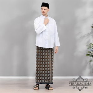 May include: A man wearing a white long-sleeved shirt, a patterned sarong, black sandals, and a black cap. The sarong features a repeating geometric pattern in shades of brown, black, and blue. The outfit is a traditional style.