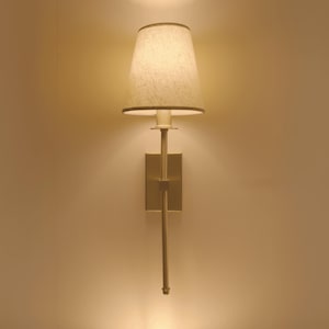 Elegante aplique de pared de latón con pantalla de tela: lámpara clásica para dormitorio o sala de estar.