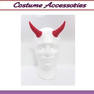 May include: A pair of red devil horns made of plastic. The horns are attached to a white mannequin head.