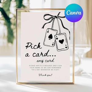 May include: A framed sign with the text "Pick a card... any card" and instructions to write a message. The sign features illustrations of two playing cards and a Canva logo in the upper right corner.