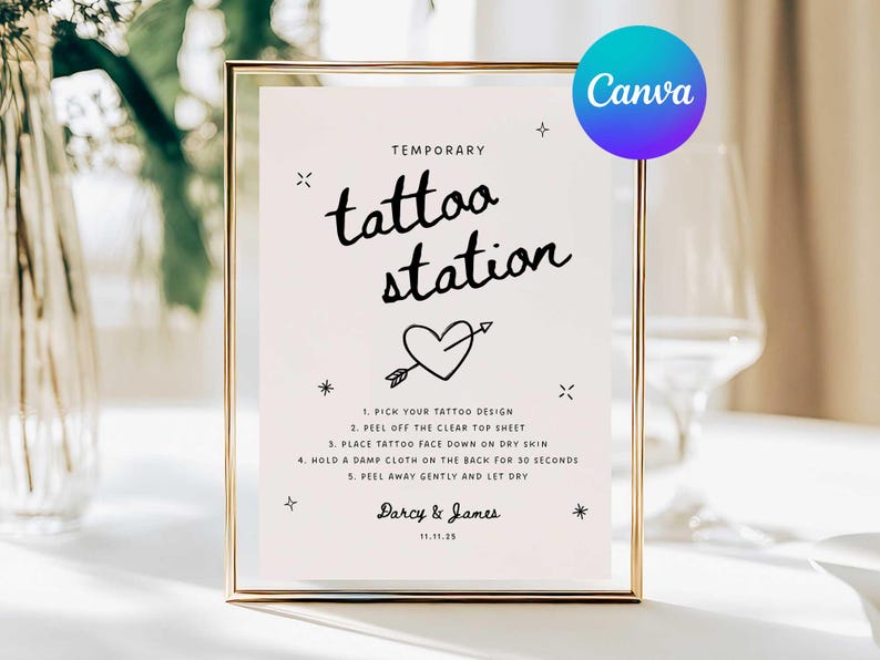 May include: A framed sign with the words "tattoo station" in a handwritten font, with a heart and arrow graphic. The sign includes instructions for applying temporary tattoos and the names Darcy & James, with the date 11.11.25.