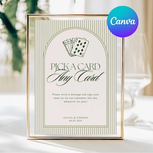 May include: A framed sign with the text "PICK A CARD, Any Card" in elegant script. The design includes a deck of cards illustration and vertical stripes. The sign also includes the names Olivia & Conrad and the date 04.05.2026.