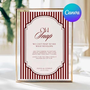 May include: A framed sign with a gold border and a burgundy and white design. The sign reads "Oh Snap" and includes instructions for using a camera to capture special moments. The Canva logo is in the upper right corner.