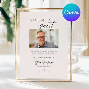 May include: A framed memorial sign with a gold border. The sign reads "SAVE ME A seat" above a photo of a man wearing glasses. Below the photo, text reads "IN LOVING MEMORY OF Steve Palmer, FATHER OF THE BRIDE."