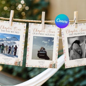 May include: Three rectangular photo cards hanging on a string with wooden clips. Each card features a floral border, a central photograph, and text including Chapter One The Day We Met, Chapter Four Our First Holiday, and Chapter Seven The Proposal.