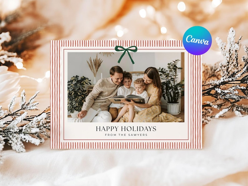 May include: Holiday card with a family reading a book. The card has a red and white striped border and a green bow. The text reads "Happy Holidays From The Sawyers."
