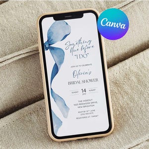 Può includere: Uno smartphone mostra un invito a un addio al nubilato. Lo schermo presenta un design a nastro blu acquerello e il testo "Something blue before 'I DO'" insieme ai dettagli dell'evento. Il telefono ha una custodia dorata ed è appoggiato su un tessuto beige.