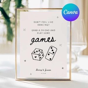 Könnte beinhalten: Ein gerahmtes Schild mit dem Text "Keine Lust zu tanzen? Schnapp dir einen Freund und spiel ein paar Spiele." Das Schild zeigt Würfel- und Domino-Illustrationen. Die Namen "Darcy & James" und das Datum "11.11.25" sind ebenfalls enthalten.