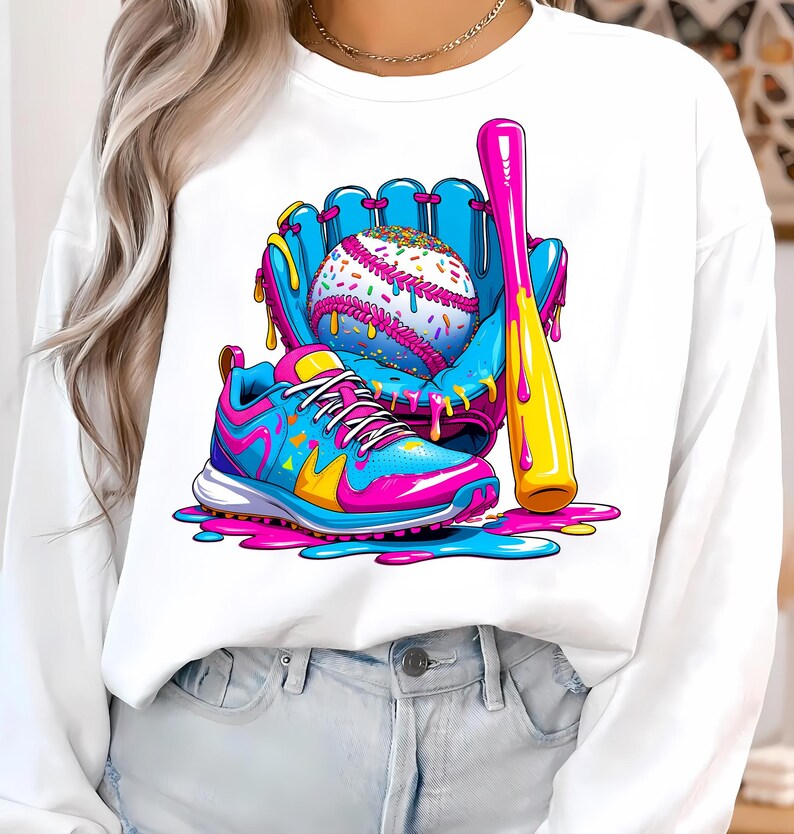 May include: A white sweatshirt with a baseball-themed illustration. The design features a baseball, glove, bat, and a trainer, in bright blue, pink, and yellow. The baseball is decorated with colourful sprinkles.