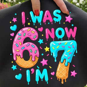 May include: Black graphic design with the text "I WAS 6 NOW I'M 7". The numbers 6 and 7 are designed as donuts and ice cream cones. Pink, blue, yellow, and orange colors are used in the design.