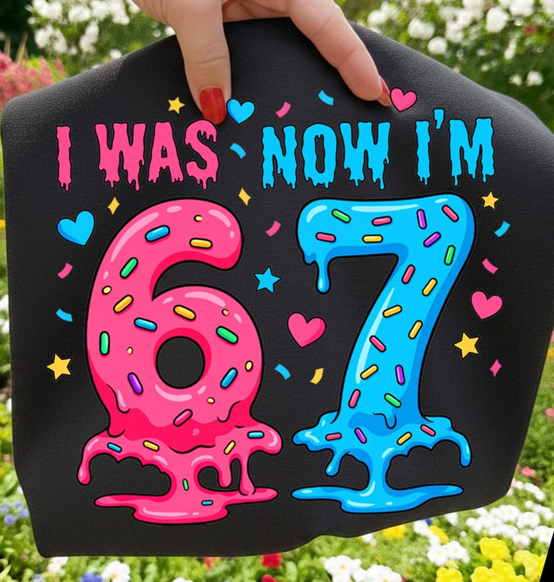 May include: Black fabric with the text "I WAS NOW I'M" in pink and blue. The numbers "67" are designed to look like melting donuts, with sprinkles and heart and star accents. A fun, colorful design for a birthday celebration.