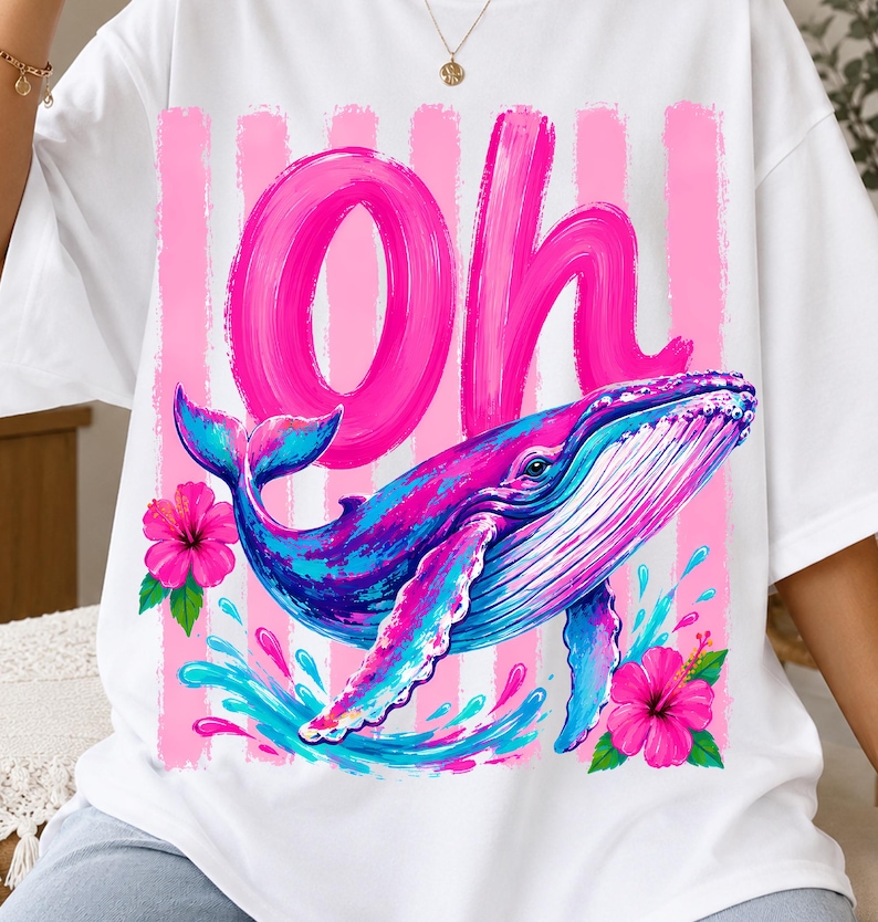 Pu&ograve; includere: Una t-shirt bianca con la scritta Oh in grandi lettere rosa effetto pennellata, una balena blu e rosa che nuota tra spruzzi d'acqua e due fiori di ibisco rosa acceso su uno sfondo a righe verticali rosa.