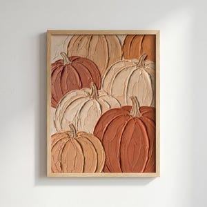 May include: A framed wall art piece featuring a textured impasto painting of multiple pumpkins in shades of cream, beige, tan, and burnt orange. The artwork displays thick, visible brushstrokes and raised paint layers, encased in a light wood frame.