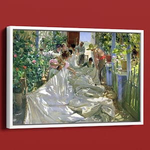 May include: A framed art print of a painting depicting a group of people outdoors. The scene shows figures interacting with large white fabric, surrounded by greenery and a blue-painted structure. The artwork has a warm, sunny color palette.