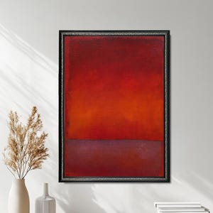 May include: Abstract painting in a black frame with a red and purple color scheme. The painting is divided into two sections, with the top section being a vibrant red and the bottom section being a deep purple.
