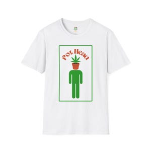 May include: White t-shirt with a green and orange graphic. The graphic features a stick figure with a pot of cannabis on its head, and the words "Pot Head" in orange above the figure.