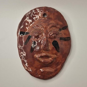 May include: A white ceramic mug with a black handle and the text "But First, Coffee" in a black, bold font. The mug is on a white surface.