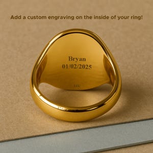 May include: A gold-colored ring with an engraved interior. The engraving reads "Bryan 01/02/2025". The ring is marked "14K" and is set against a neutral background. The text above the ring says, "Add a custom engraving on the inside of your ring!"