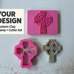 May include: A pink rectangular clay stamp featuring a Celtic cross design, a pink cross-shaped clay cutter, and a grey moulded clay cross. Text on the image reads: YOUR DESIGN Custom Clay Stamp + Cutter Set. The items are arranged on a white surface.