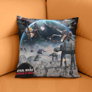 May include: A square pillow featuring a Star Wars battle scene with spaceships, AT-AT walkers, and a planet in the background. The pillow has the text "STAR WARS EMPIRE AT WAR" at the bottom.