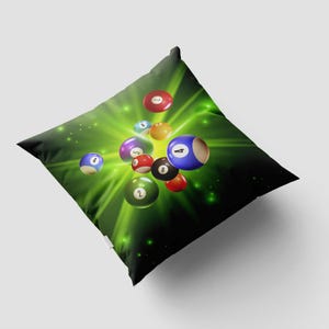 May include: Square throw pillow featuring a vibrant design of billiard balls against a bright green and black background. The balls are numbered and appear to be floating. The pillow is a decorative item for a game room or living space.