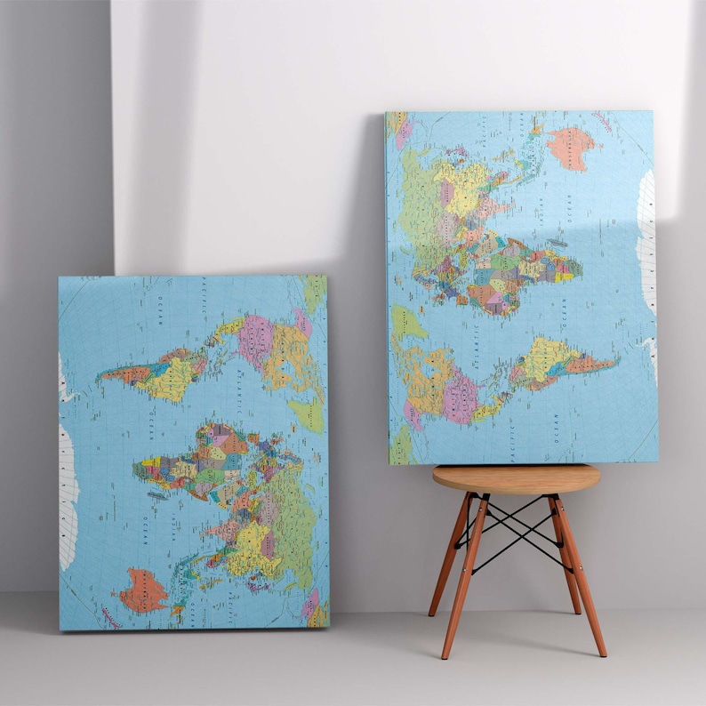 May include: Two world maps printed on canvas, one is leaning against a white wall and the other is on a wooden easel. The maps are blue with colorful borders around each country.
