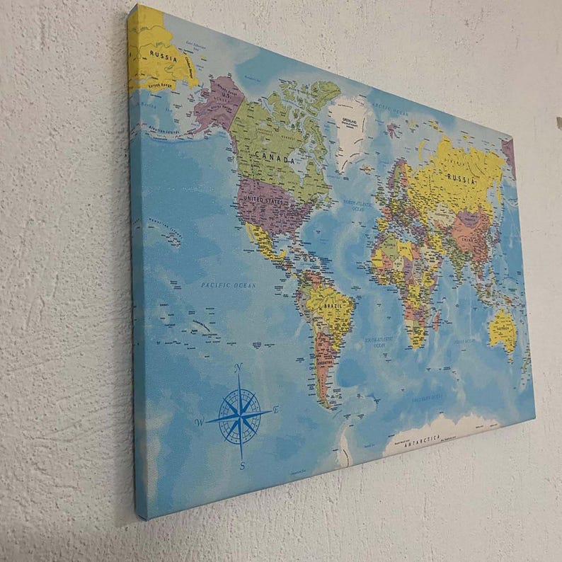 May include: A blue world map printed on canvas with country borders and names. The map includes a compass rose and the words "Pacific Ocean" and "Antarctica".