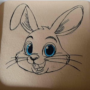 May include: A black and white line drawing of a cartoon bunny rabbit with blue eyes. The bunny is smiling with its mouth open and has whiskers.